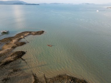 Tropikal bir adanın kıyı şeridine demirlemiş ahşap yelkenli teknelerinin hava manzarası, kıyıya yakın mavi sularda bulunan teknelerin yer aldığı pitoresk deniz manzarası. Egzotik manzara.