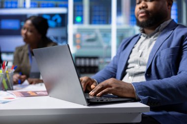 Afrika amerikan güneş panelleri yönetici sorun giderme teknik sorunlarını dizüstü bilgisayarla hallediyor. Photovoltaics fabrika yöneticisi laptop kullanarak verileri analiz ediyor, sistem sağlık ölçümlerini gözden geçiriyor, kapatıyor