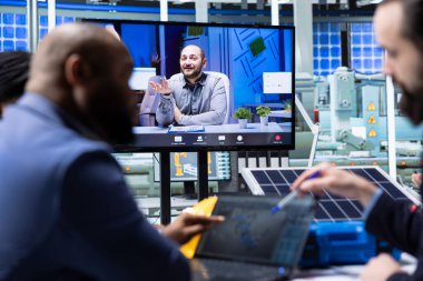Photovoltaics fabrika yöneticileri internet video çağrısı sırasında tablette 3D yazılımla kat tasarımlarını görselleştirir. Güneş panelleri telekonferans toplantısında CAD simülasyonlarına bakan iş adamları yerleştiriyor