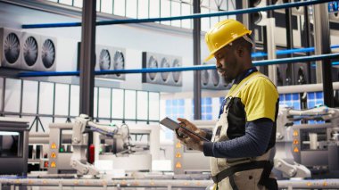 Akıllı fabrika uzmanı otomatik iş akışlarını ve kontrol sistemlerini bilgisayara aktarmak için tablet kullanır. Endüstri 4.0 fabrika teknisyeni sensörleri cihaz, kamera A kullanarak üretime entegre ediyor