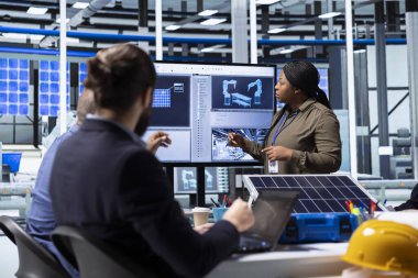 Hissedarlar, görüntüdeki verilere bakarak yenilenebilir enerji yatırımlarında işbirliği yapıyorlar. Photovoltaics tesis yönetimi ekibi monitörde üretim ekipmanlarına bakıyor, beyin fırtınası yapıyor.