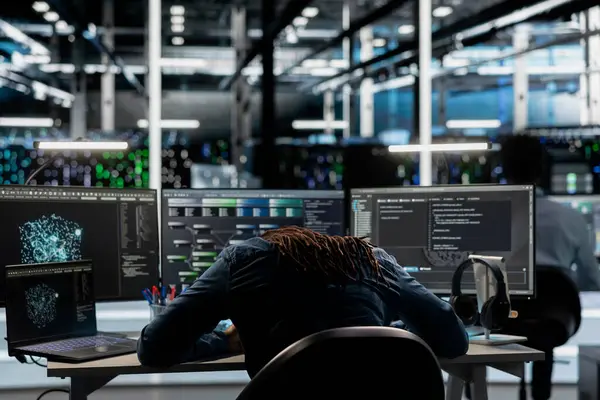 Yorgun sunucu mühendisi, yapay zeka algoritmalarını kullanarak büyük veri tabanlarını analiz ederken uykuya dalıyor. Yorgun veri merkezi çalışanı tesis verilerindeki kalıpları tanımak için derin öğrenim kullandıktan sonra yoruldu