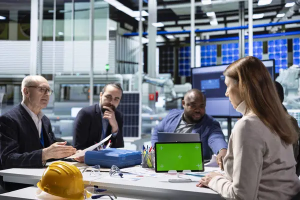 Endüstriyel fabrika yönetimi yöneticisi, yeşil ekran tableti kullanan yatırımcılara araştırma ve geliştirme ve iş stratejileri sırasında bulunan operasyonel içgörüleri sunar