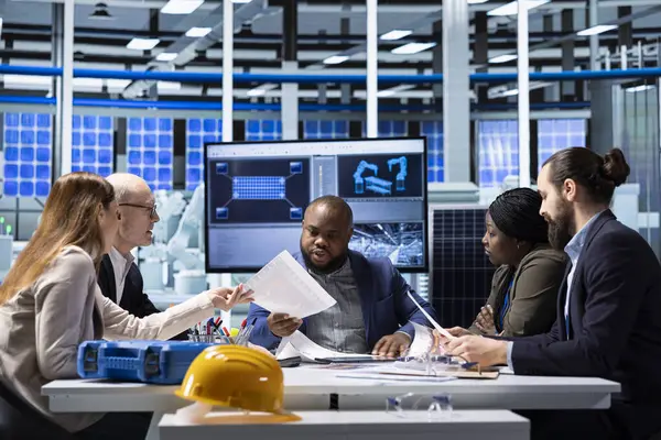 Güneş panelleri fabrika hissedarları rekabet analizi yapıyor, dosyalara bakıyor. Fotovoltaik fabrikası hissedarları potansiyel yatırım fırsatları üzerine araştırma yapıyor, belgeleri okuyorlar