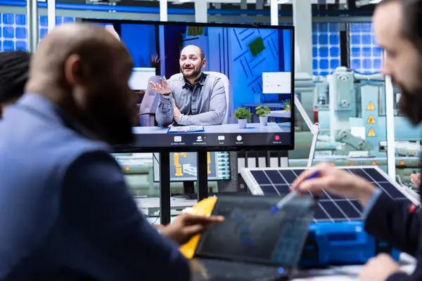 Photovoltaics fabrika yöneticileri internet video çağrısı sırasında tablette 3D yazılımla kat tasarımlarını görselleştirir. Güneş panelleri telekonferans toplantısında CAD simülasyonlarına bakan iş adamları yerleştiriyor