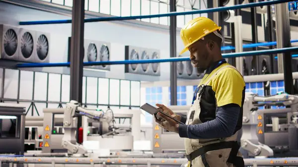 Akıllı fabrika uzmanı otomatik iş akışlarını ve kontrol sistemlerini bilgisayara aktarmak için tablet kullanır. Endüstri 4.0 fabrika teknisyeni sensörleri cihaz, kamera A kullanarak üretime entegre ediyor