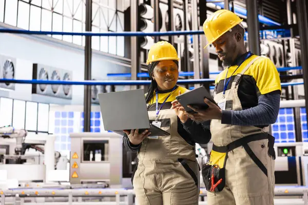 Mühendisler otomatikleştirilmiş fabrikada verimliliği arttırmak ve izlemek için laptop ve tablet üzerinde dijital arayüzler kullanıyorlar. Endüstri 4.0 yenilik akıllı üretim tesislerinde endüstriyel otomasyona güç sağlıyor.