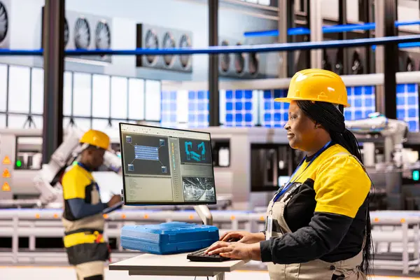 Otomasyon mühendisi endüstriyel tesiste güneş paneli yazılımını koruyor. Profesyonel kadın teknisyen sistem performansını optimize ediyor ve akıllı üretim tesisinde otomatik makineleri yönetiyor..