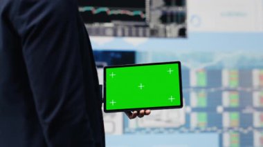 Dijital çalışma alanında yeni bir finans stratejisi ve raporları keşfetmek için elinde fotokopi alanı olan genç bir patron elinde tablet tutuyor. Modern iş zekası ve verimliliği. Kamera A.