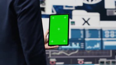 Girişimci, kurumsal performansı ve gelecek başarı planını optimize etmek için uzay ekranı ve gösterge panelleri, finans trendleri ve KPI metrikleri ile tableti elinde tutuyor. Büyüme planı. Kamera A.