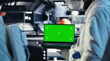 Astronotlardan oluşan bir ekip, yeşil ekran dizüstü bilgisayardaki uzay görevi kayıtlarında insan genleşmesini kontrol ediyor. Kozmonotlar, insanoğlunun hayatta kalma seferi sırasında kroma anahtar defteri kullanıyorlar, kamera B