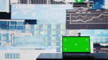 Boş iş sahasında yeşil ekranlı bir dizüstü bilgisayar görüntüsü, bilgi grafikleri ve karar verme ve strateji planlaması raporları var. Yapay zeka veri görselleştirmesi. Kamera B.