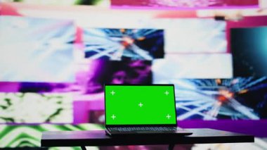 Kablosuz bilgisayar, renkli görsel sanat klipleriyle çevrili, karanlıkta parlayan ve kulüp atmosferini gösteren krom anahtar ekranı çalıştırıyor. Şehir ışıkları ve titreşimlerle dolu bir gece hayatı ortamı. Kamera B.
