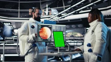 Astronotlar uzay gemisinden çıkmadan önce izole ekran tabletindeki analizleri inceliyor. Gezegen A 'ya indikten sonra kroma anahtar cihazının parametrelerini doğrulayan kozmonotlar.