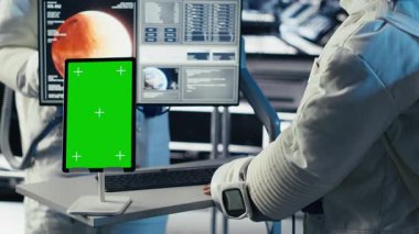 Astronotlar uzay gemisinden çıkmadan önce izole ekran tabletindeki analizleri inceliyor. Gezegen B 'ye indikten sonra kroma anahtar aygıtı parametrelerini doğrulayan kozmonotlar.