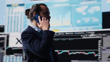 Erkek girişimci KPI ölçümleri hakkında bilgi paylaşmak ve şirket performansını değerlendirmek için bir telefon görüşmesi yapıyor. Uzman, kazancını arttırmak için uzaktan iletişim kullanıyor. Kamera A.