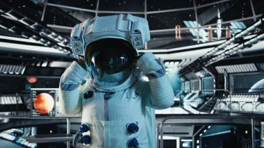 Yörünge istasyonu dışında planlanan operasyonlara çıkmadan önce miğfer tutan mutlu astronot portresi. Uzay aracında gülümseyen kozmonot uzak gezegen yüzeyine yaklaşıyor, kamera A