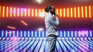 Neon ışıklı fütüristik ortamda poz veren trend genç insan, gençlik kültürünün, yaratıcılığın ve minimalizmin özünü retro dijital bükülme ve güçlü sokak giyimi etkisiyle yakalıyor. Kamera B.