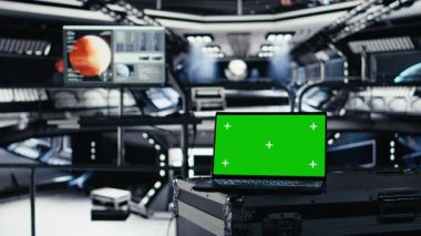 Mars telemetrisini izleyen yüksek teknolojili görüntülerle çevrili yörünge istasyonundaki model dizüstü bilgisayar. Gerçek zamanlı görev kontrolü ve uzay aracı durum güncellemelerini sağlayan yeşil ekran defteri