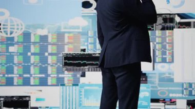 Akıllı telefon görüşmesinde uzman işadamı finans ve analizi tartışıyor, şirket stratejisi kuruyor. Veri tablolarıyla çevrili, dijital yenilik ve şirket büyümesi planlanıyor. Kamera B.