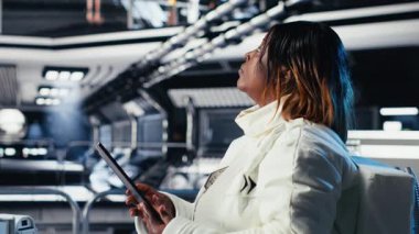 Yüksek teknolojili uzay aracının içindeki astronot rutin görev kontrolü sırasında Kırmızı Gezegen Özet Analizlerini kontrol ediyor. Mars verilerini gösteren monitörün yanında duran aygıtı kullanarak Yörünge İstasyonu Kozmonotu