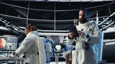 Kozmonot uzay gemisinde tablet kullanıyor. İnsanoğlunun hayatta kalma seferi sırasında güvenlik kontrolü yapıyor. Uzay görevinde insan genleşmesi sırasında yaşam destek sistemlerini izleyen astronotlar, kamera B