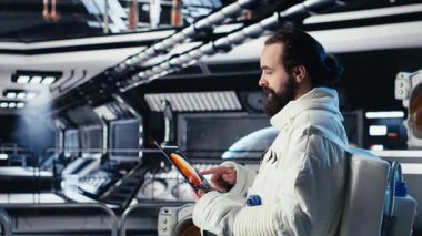 Gelişmiş teknoloji uzay aracındaki astronot ekibi rutin görev kontrolü sırasında Kırmızı Gezegen Özet Analizlerini kontrol ediyor. Takım çalışması Yörünge İstasyonu mürettebatı Mars verilerine bakmak için aygıt kullanıyor