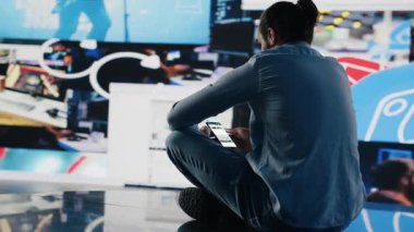 Çevrimiçi platformlardaki aşırı bilgiler ve aşırı sosyal medya kullanımından dolayı sosyal kaygı çekiyor. Kendine güveni az, bunalmış bir adam. Kamera A.