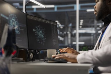 Veri merkezinde bilgisayar üzerinde çalışan bir mühendis yapay zeka altyapısını barındırıyor. Yapay zeka makinesi öğrenme süper bilgisayarlarıyla dolu sunucu merkezinde bilgisayar kullanan bilişim uzmanı