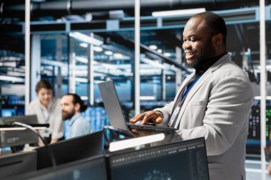 Süper bilgisayar yazılımlarını güncellemek için dizüstü bilgisayar kullanan Happy Veri Merkezi Yöneticisi, ağ viralizasyonunu yapılandırıyor. Donanım ayarlarını doğrulamak için dizüstü bilgisayar kullanan Jolly sunucu merkezi IT profesyoneli