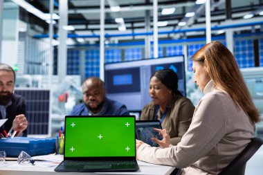 Üretim fabrikasındaki hissedarlar kroma anahtar dizüstü bilgisayarı üzerinde araştırma yapıyorlar. Yatırımcılar ve fabrika yönetimi yeşil ekran not defteri kullanarak ekipman üretim genişlemesi stratejilerini analiz ediyor