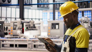 Otomatik sistemleri test eden akıllı bir fabrika uzmanı. Operasyonel bütünlüğü izliyor. Endüstri 4.0 tesis teknisyeni hasar tespiti ve onarım ekipmanları, kamera A