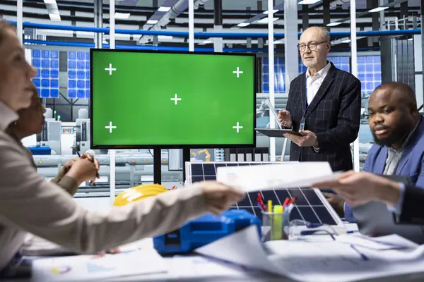 Endüstriyel fabrika yöneticileri ürün yeniliklerini kroma anahtar ekranı kullanarak sergiliyorlar. Müşteriler için satış sunumu yapan fabrika işadamları, izole ekran monitörü kullanarak güneş paneli çözümleri gösteriyorlar