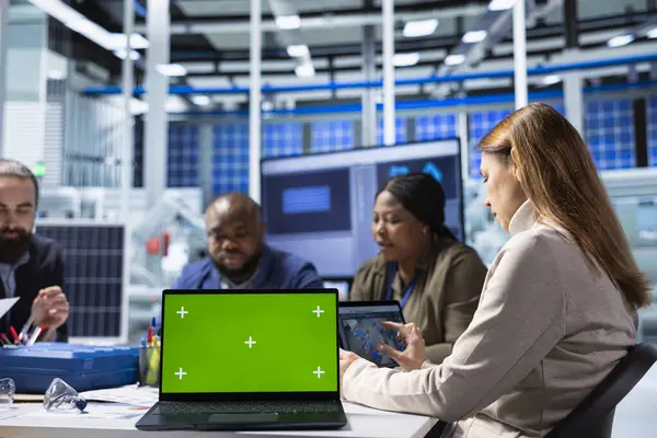Üretim fabrikasındaki hissedarlar kroma anahtar dizüstü bilgisayarı üzerinde araştırma yapıyorlar. Yatırımcılar ve fabrika yönetimi yeşil ekran not defteri kullanarak ekipman üretim genişlemesi stratejilerini analiz ediyor