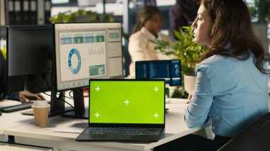 Muhasebecinin yanındaki yeşil ekran model dizüstü bilgisayar raporları kontrol ettikten sonra bilgisayara mali verileri giriyor. Ofiste çalışan iş kadınının yanında Chroma anahtar defter, çapraz veri, kamera A