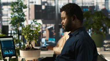 Modern ofisteki mali tabloları inceleyen çalışanlar iş performans ölçümlerini analiz ediyorlar. Veri eğilimlerini ve stratejik görüşleri inceleyen bir profesyonel, kamera A