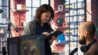 Ofisteki işçiler, sanal ev planlaması için kullanıcı arayüzü sağlayan bir evin içini tasarlamak için CAD yazılımı kullanıyorlar. Geliştiriciler takımı mimari düzen ve düzenlemeler yaratıyor. Kamera B.