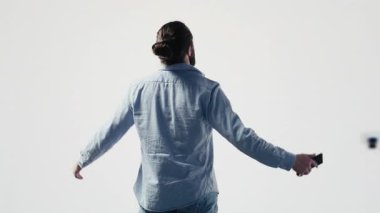 Mobil bildirimleri ve görsel hikaye anlatımlarını kontrol eden, sosyal ağda takipçilerle iletişim kuran ve yaratıcılığını sergileyen bir erkek etkili. Bağlı dijital dünya, marka sesi. Kamera A.