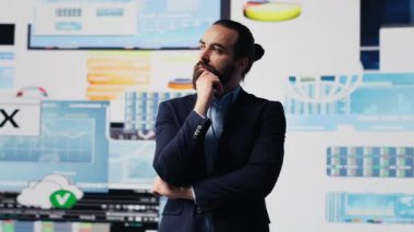 İşadamı, dijital teknolojiyle bilgi grafikleri ve mali raporları değerlendirirken finansmanı artırmak için yeni bir çözüm düşünüyor. Uzun vadeli başarı ve büyüme planlıyorum. Kamera A.