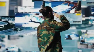 Gazi, bir kontrol merkezinde uydu verilerini inceledikten sonra savaş planlama taktikleri ve savaş alanı detayları üzerinde çalıştıktan sonra askeri selam veriyor. Ulusal güvenlik için yüksek teknoloji ordu ortamı. Kamera B.