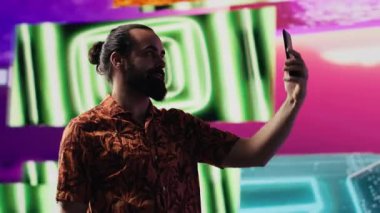 Genç erkek sanatçı kendini özçekim ve videolarla kaygısız hissediyor, siber punk görsel sanatıyla cep telefonuyla fotoğraf çekiyor. Eğlenceli insan gece hayatı titreşimlerini sever. Kamera A.