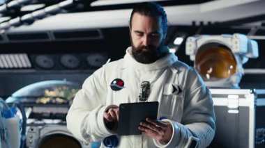 Astronot Mars seyahati sırasında tablet üzerindeki uzay görevi verilerini kontrol ediyor. Yıldız gemisindeki kozmonot, uzun vadede insanlığı destekleyen Kızıl Gezegen seferi için hazırlanıyor, kamera B