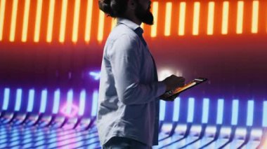 Parlayan neon ışıkların altında parlak renkler ve fütüristik bir atmosferle çevrili havalı biri duruyor. Gece hayatı sahnesinde bireysellik, kentsel tarz ve yaratıcı tavır. Kamera A.