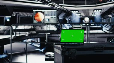 Kızıl Gezegen yolculuğu sırasında kokpitteki yörüngesel navigasyon verileri için kullanılan model defter. Mars gösterge panelini gösteren monitörün yanındaki uzay aracı kontrol arayüzünü çalıştırmak için kullanılan yeşil ekran dizüstü bilgisayarı