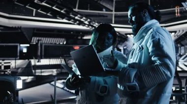 Astronot meslektaşıyla konuşuyor, uzay görevi sırasında bilimsel deneyler yapıyor. İnsanoğlunun hayatta kalma seferi sırasında uzayda kontrollü testler yapan takım çalışması kozmonotları, kamera A