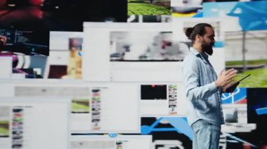 Elsiz mikrofonla, erkek trend belirleyicisi yenilikler için içgörü sunan canlı bir sunuma ev sahipliği yapıyor. Konuşmacı izleyicilerle çevrimiçi eğlence hakkında konuşuyor. Kamera B.