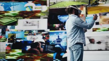 Genç rahat adam sosyal medya platformları için yapay zeka bağlantısı gösteren 3 boyutlu kullanıcı arayüzü tasarımı için VR gözlüğü kullanıyor. Dijital dünyada eğlence sektöründe çalışan erkek sosyal ağ kullanıcısı. Kamera B.