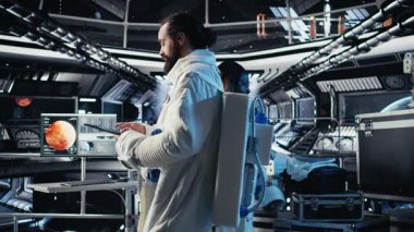 Astronot, uzay istasyonunun dışına çıkmadan önce yaşam destek sistemlerini izliyor. Kozmonot, Kırmızı Gezegen A 'ya indikten sonraki görev parametrelerini doğruluyor.