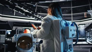 Yüksek teknolojili uzay aracının içindeki astronot rutin görev kontrolü sırasında Kırmızı Gezegen Özet Analizlerini kontrol ediyor. Mars verilerini gösteren monitörün yanında duran aygıtı kullanarak Yörünge İstasyonu Kozmonotu