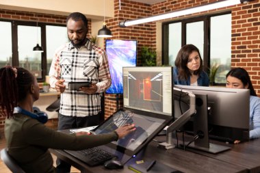 Modern çalışma alanındaki yaratıcı beyin fırtınası sırasında dijital teknolojiden yararlanan çok ırklı meslektaşlar. Ofiste proje tasarımlarını geliştirmek için birlikte çalışan çeşitli çalışanlar..